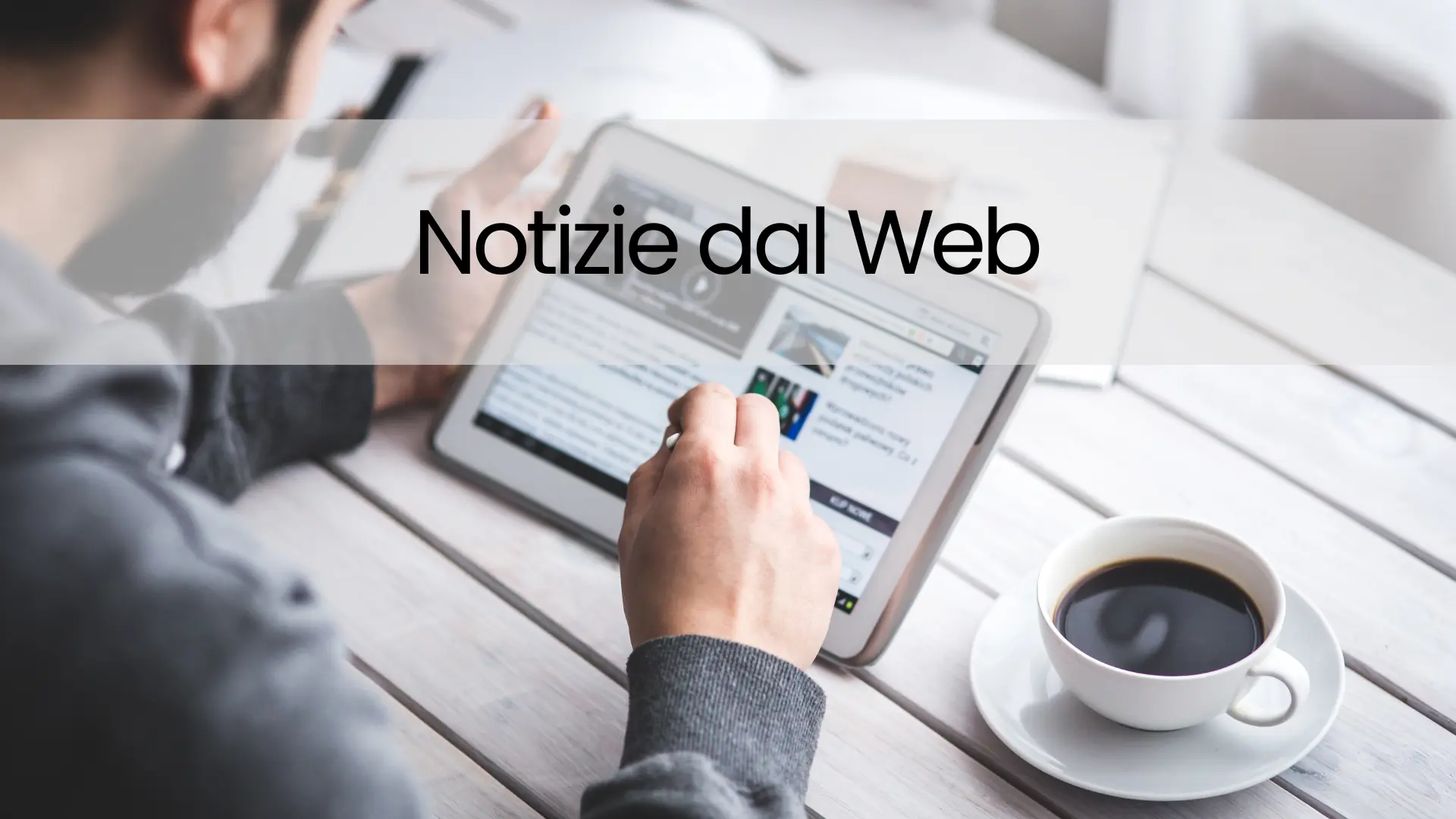 Persona che legge notizie online su tablet con caffè, immagine per la sezione Notizie dal Web del sito Mulmix.