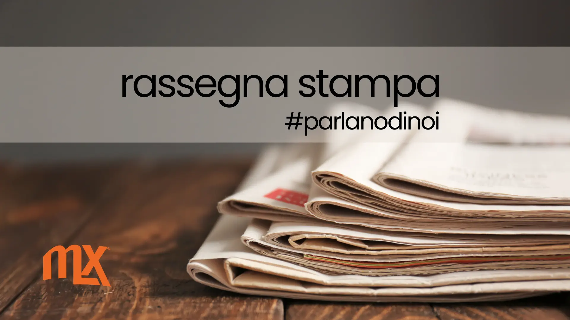 Giornali su tavolo di legno con il logo MX e scritta rassegna stampa, immagine generica per la sezione Rassegna Stampa di Mulmix.