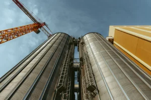 Silos CI Mulmix realizzati per Divella a Rutigliano, Puglia, ripresi dal basso con gru sullo sfondo – impianto di stoccaggio del grano.